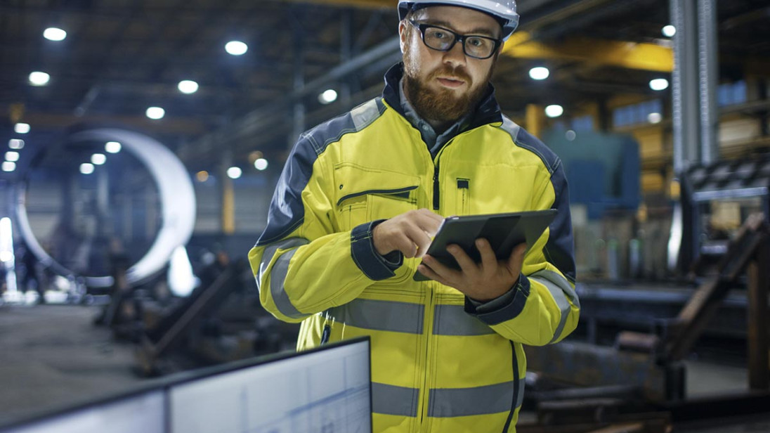 A man in yellow protection clothing working with GET Fleet management system