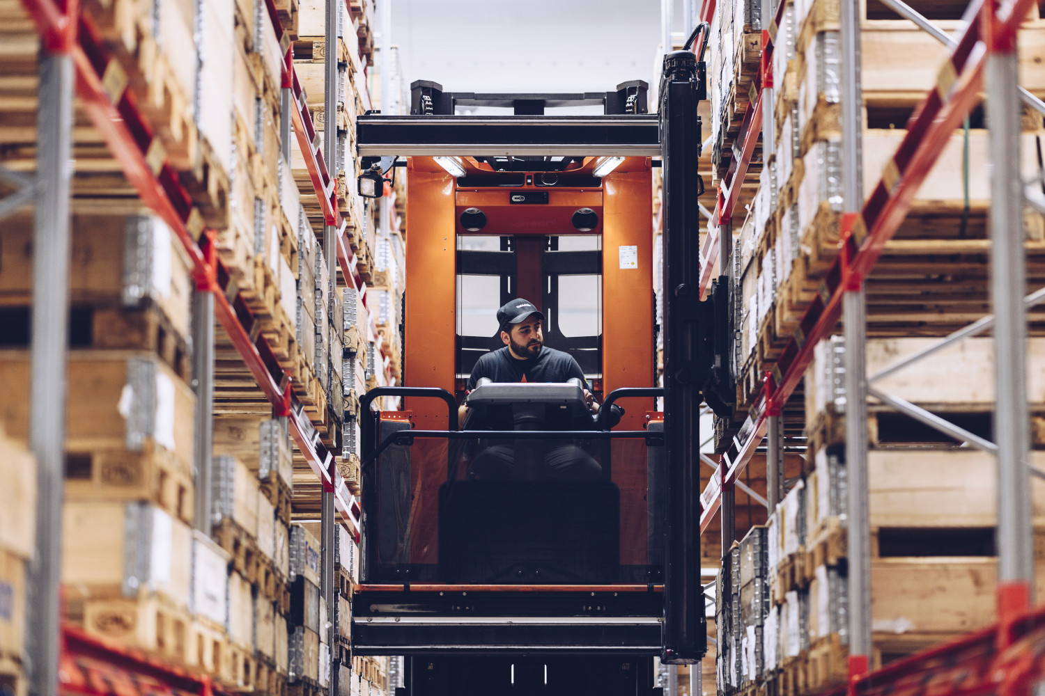 Forklift driver at warehouse shelves